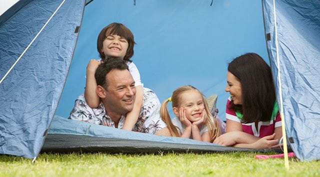 a family poking heads out of a tent