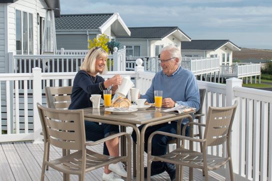 couple enjoying breakfast together on a caravan veranda